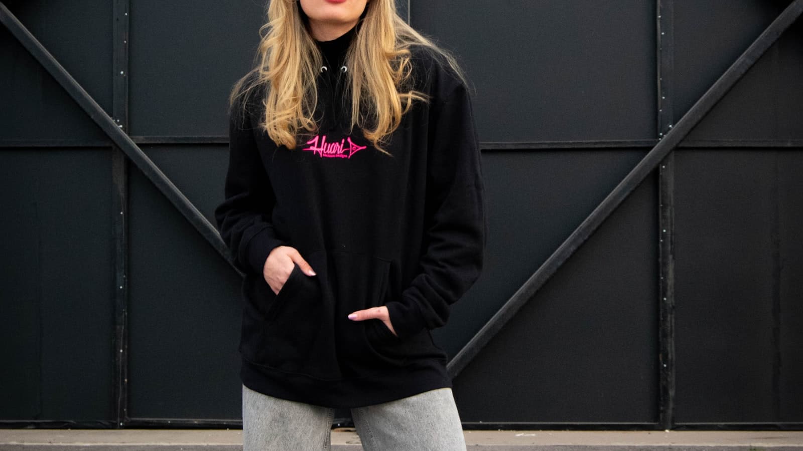 Model in an oversized rose shirt standing in a studio.
